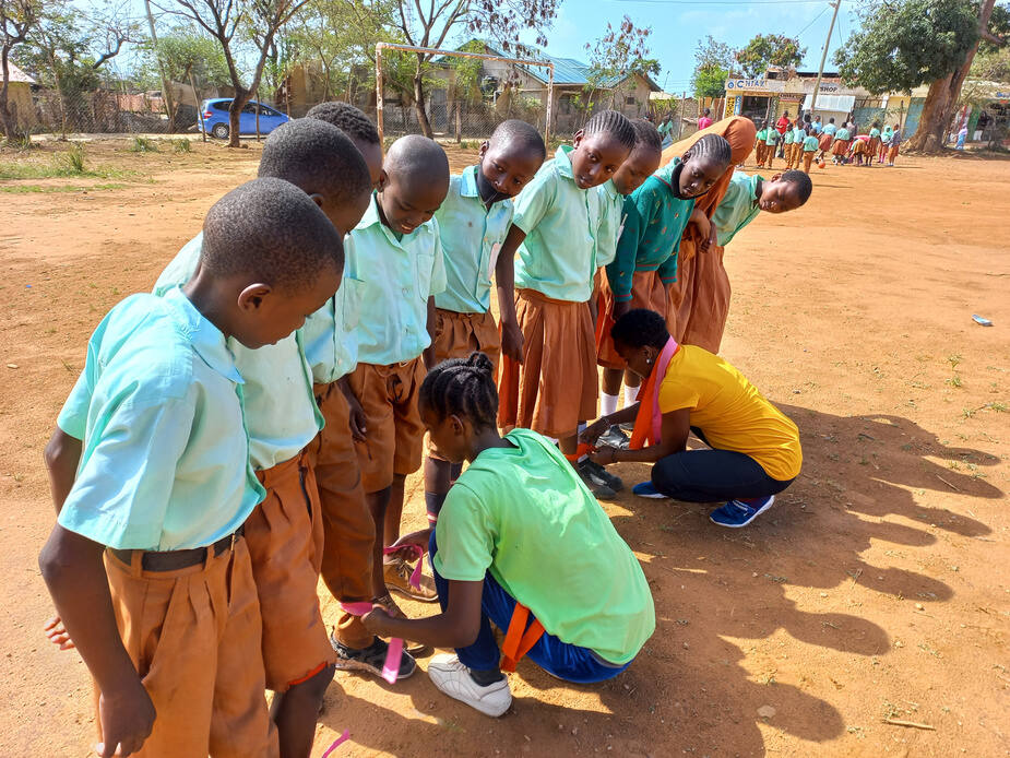 A coach helping a child tie their shoes before a sports session