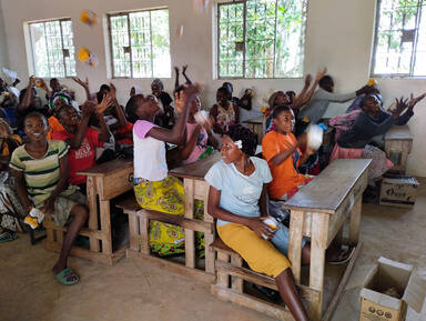 A group of young people cheering inside a classroom