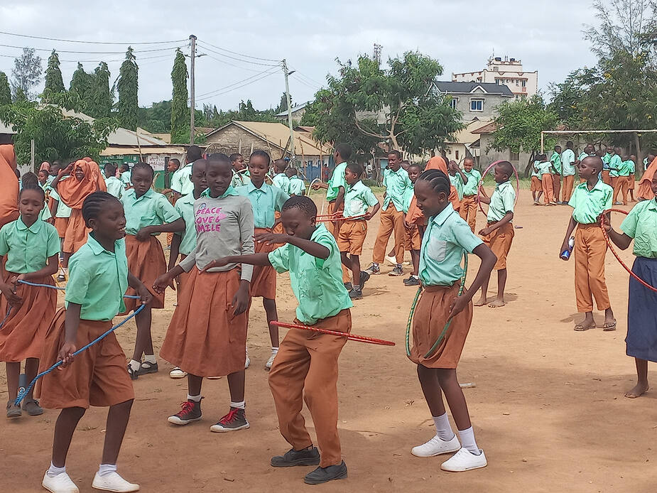 Large group of schoolchildren playing with hoops on a school field
